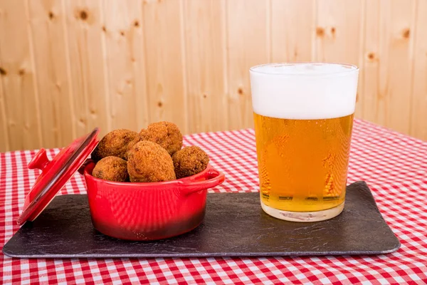 Fish croquettes in red pan and beer — Stock Photo, Image