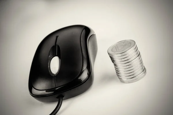 Mouse de computador e pilha de moedas — Fotografia de Stock