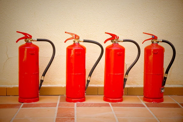 Quatro extintores de incêndio — Fotografia de Stock