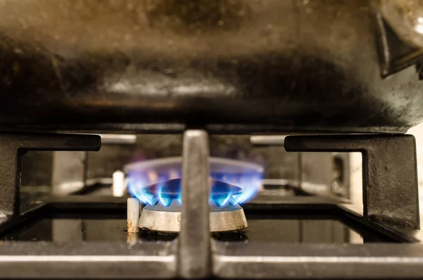 Iron pot on burning stove — Stock Photo, Image