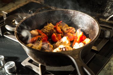 Bir dökme demir tencerede sarımsak tavuk pişirme