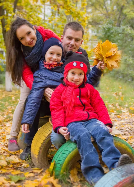 Familia con dos niños en el parque de otoño —  Fotos de Stock