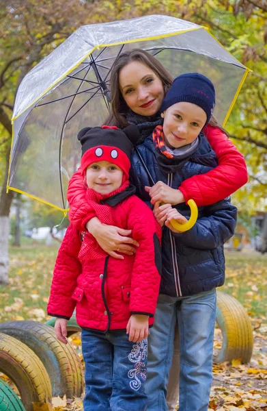 Mutter mit zwei Kindern unter Regenschirm — Stockfoto