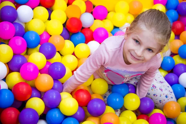 Ragazza nella stanza da gioco con molte palle colorate — Foto Stock