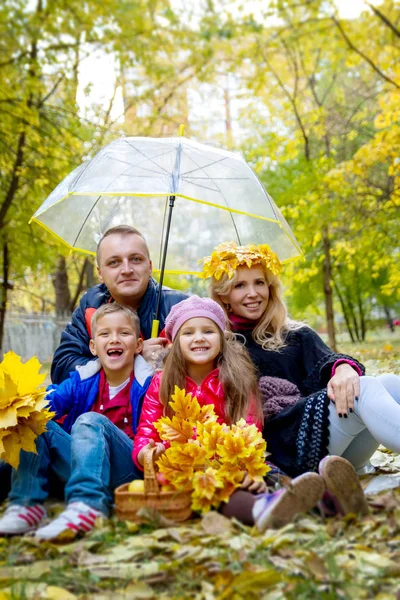 Familia de cuatro bajo paraguas en otoño — Foto de Stock