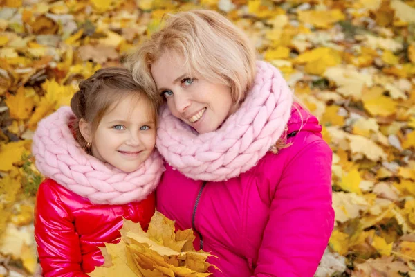 Mother and daughter looking up on autumn background — Stock Photo, Image