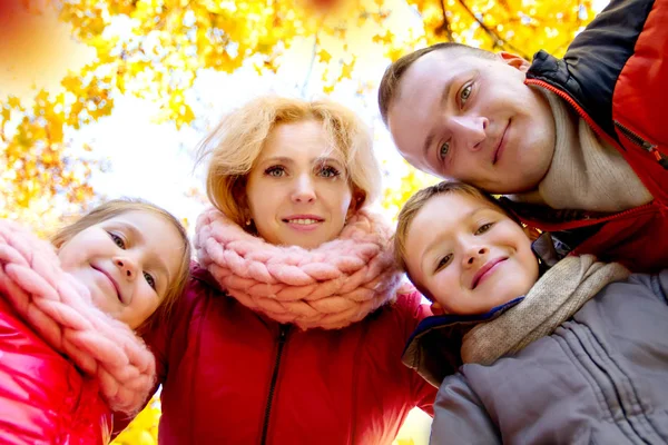 Família feliz olhando para baixo durante o outono — Fotografia de Stock