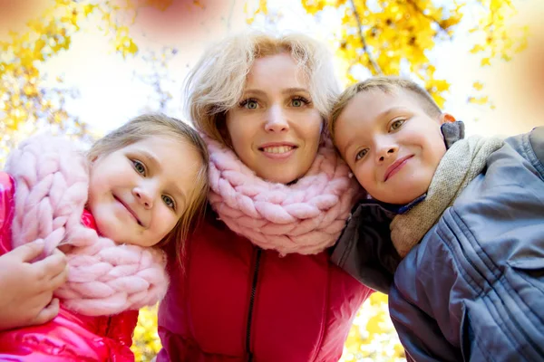 Mãe e duas crianças olhando para baixo no outono — Fotografia de Stock