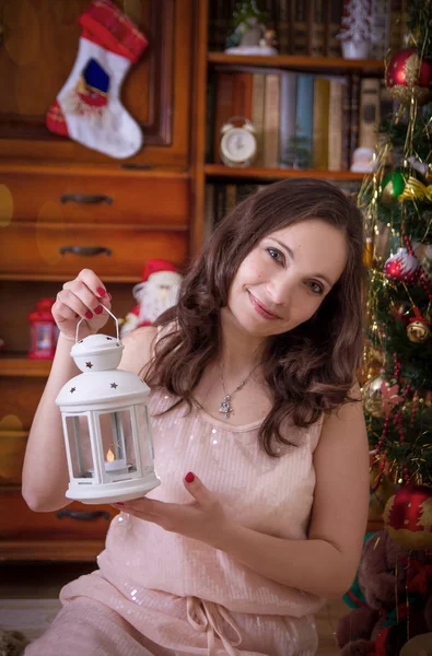 Mujer con linterna blanca bajo el árbol de Navidad — Foto de Stock