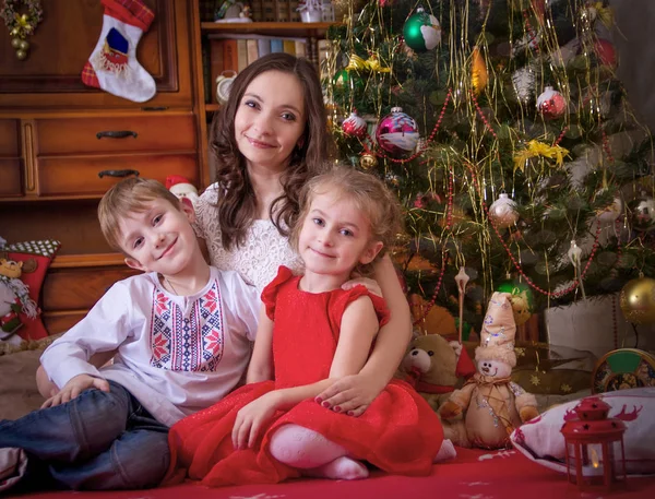母亲带着两个孩子在圣诞节与灯笼下 — 图库照片