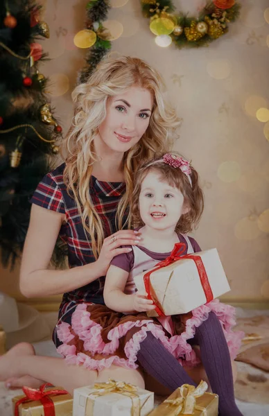 Madre e hija con caja de regalo cerca del árbol de Navidad — Foto de Stock