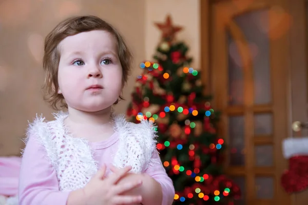 Милая девочка за рождественской ёлкой — стоковое фото
