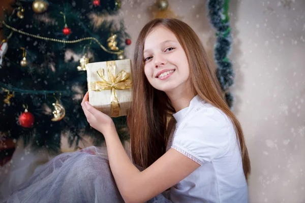Girl with gift box under Christmas tree — Stock Photo, Image