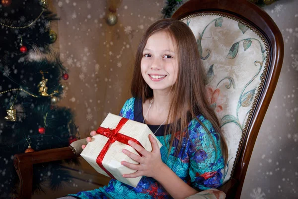 在圣诞树下的礼物盒的女孩 免版税图库照片