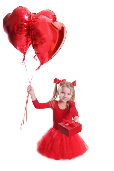 Chica en rojo con globos en forma de corazón y regalo —  Fotos de Stock