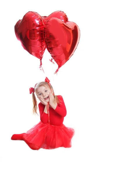 Delighted girl in red with heart-shaped balloons — Stock Photo, Image