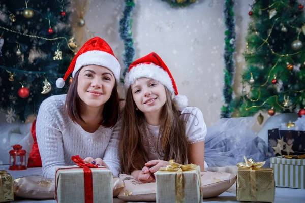 Mãe e filha deitada em chapéus de Natal — Fotografia de Stock