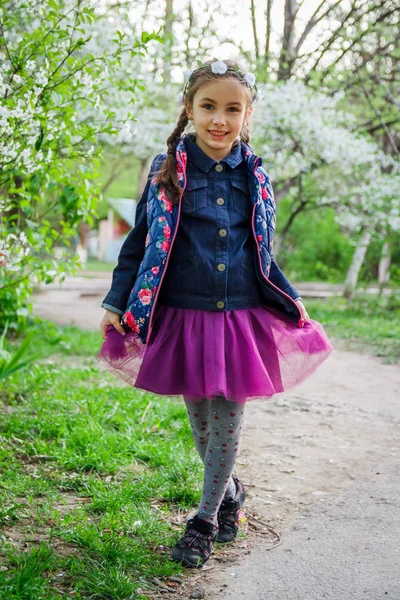 Menina em grinalda apreciando jardim de primavera — Fotografia de Stock