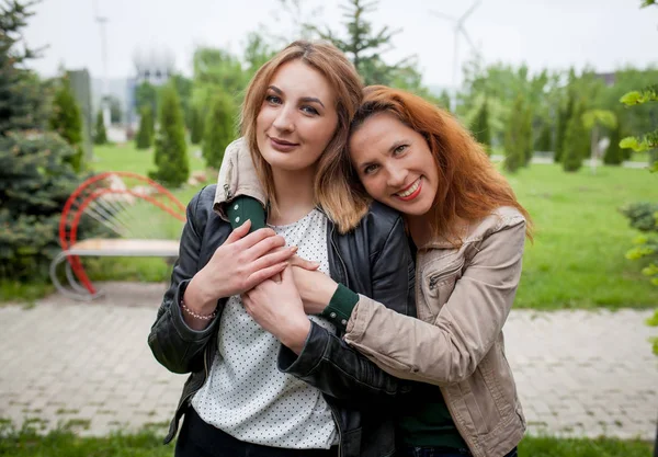 Twee gelukkige aanhankelijke vrouwen vrienden knuffelen — Stockfoto