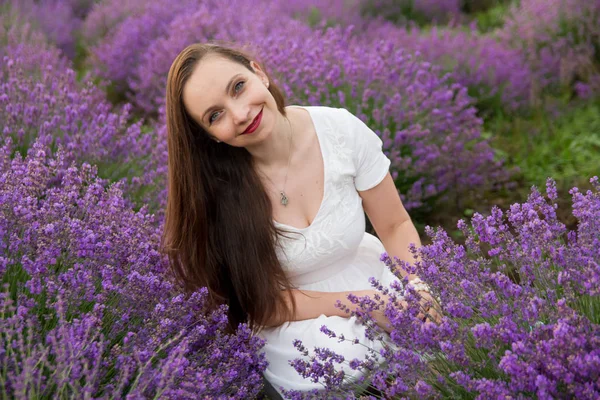 Mujer sonriente entre el campo de lavanda —  Fotos de Stock