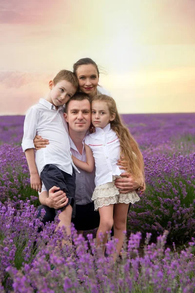 Family of four among lavender field — Stock Photo, Image