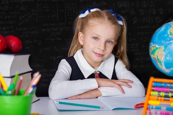 Schoolmeisje meisje met boeken in de buurt van school blackboard — Stockfoto