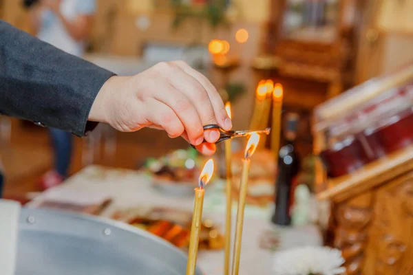 Sacerdote mão queimando o cabelo na luz da vela na igreja — Fotografia de Stock