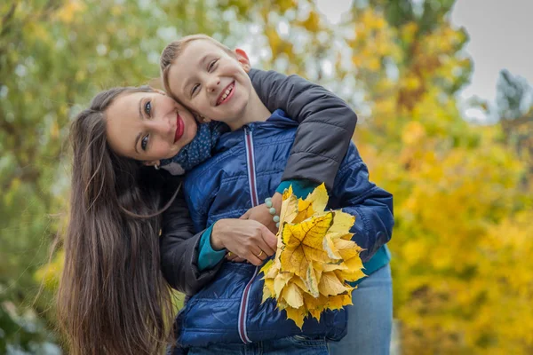 Madre che abbraccia il figlio in autunno — Foto Stock