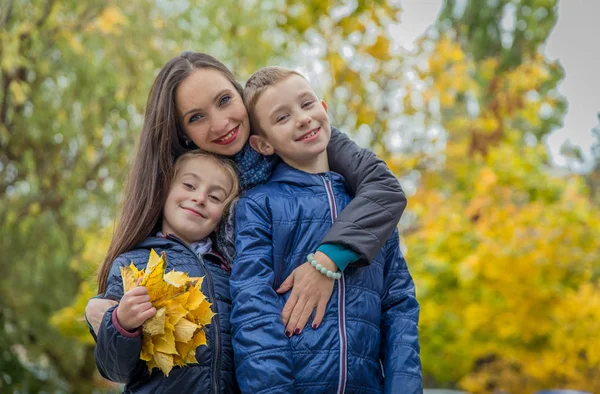 Matka i dwoje dzieci wśród jesień — Zdjęcie stockowe