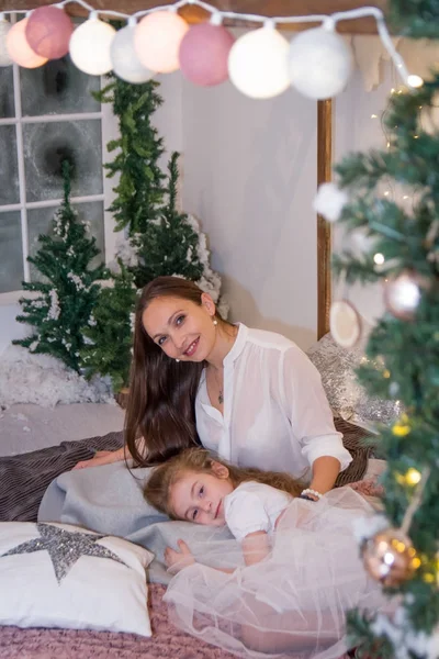 Mor och dotter liggande i vinter studio — Stockfoto