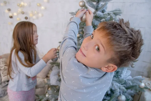 Pojke och flicka dekorera julgran — Stockfoto