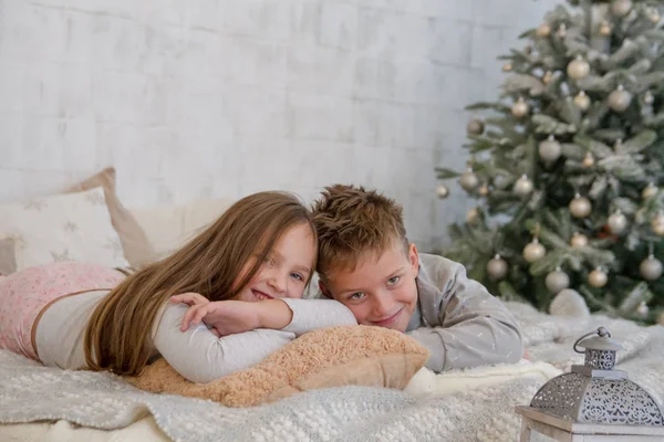 Syster och bror liggande på sängen — Stockfoto