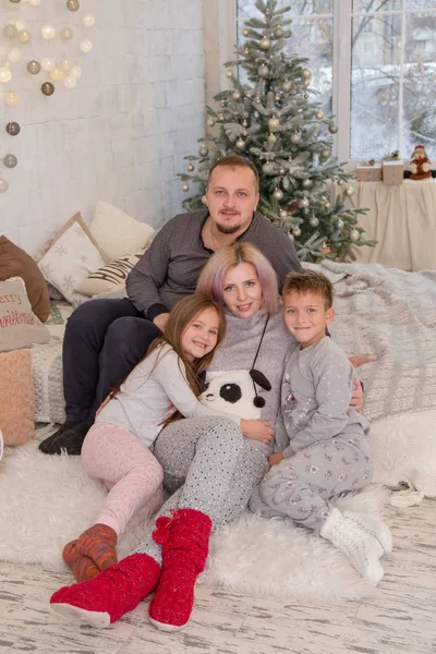 Famiglia con due bambini sotto l'albero di Natale — Foto Stock