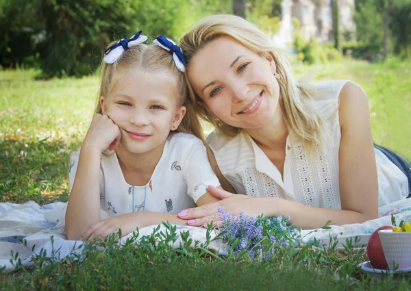 Anne ve kızı yeşil çim üzerinde yalan — Stok fotoğraf