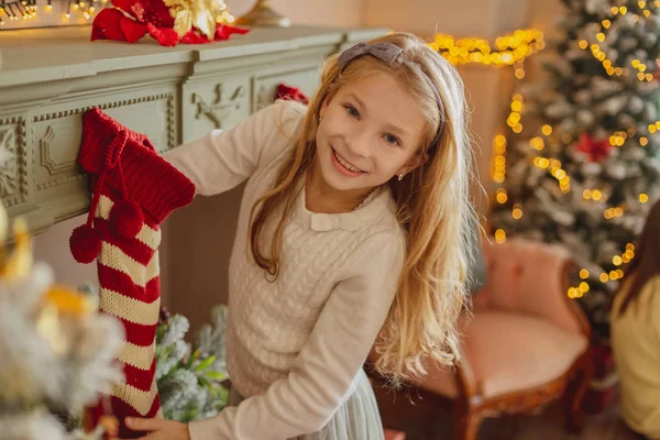 Eccitato carino giovanissima ragazza prendere regalo da natale calze — Foto Stock