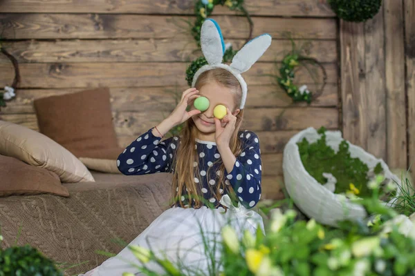 复活节快乐的女孩戴着兔子耳朵和帽子的画像 图库图片