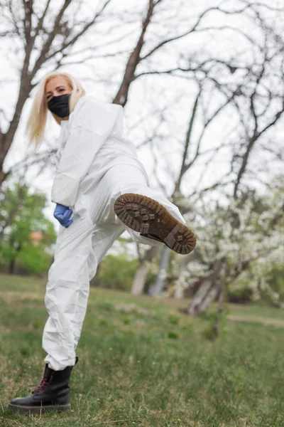 Vrouw Met Zwart Masker Wit Beschermingspak Met Been Omhoog — Stockfoto