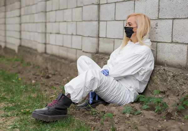 Frau Schwarzer Maske Weißer Schutzanzug Sitzend — Stockfoto