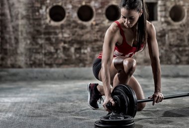 seksi fitness kadın ağır ağırlık kaldırmaya hazırlanıyor