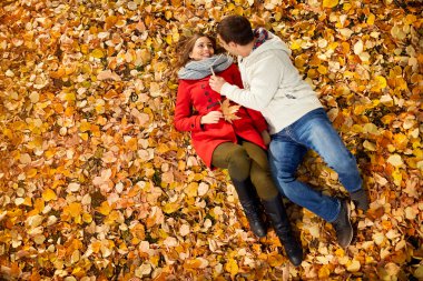 Kız arkadaşıyla parkta düşen yapraklar yatarken erkek 