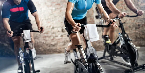 Ropa deportiva personas montando bicicletas estáticas — Foto de Stock