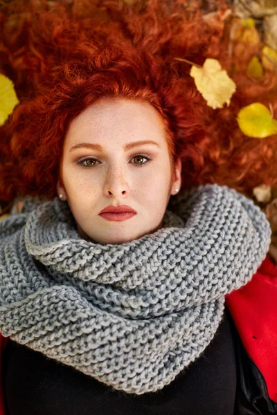 Retrato de mujer pelirroja sobre hojas caídas —  Fotos de Stock