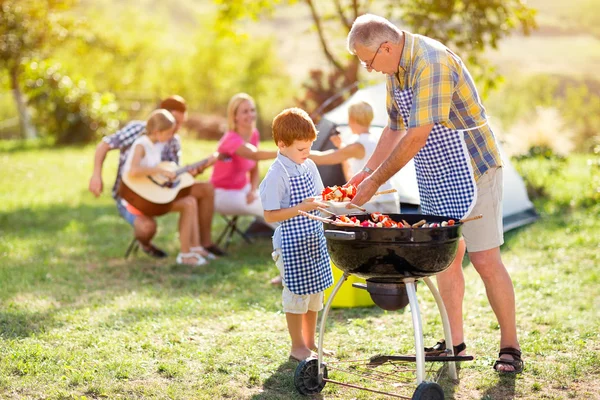 Nonno dando cibo barbecue nipote — Foto Stock