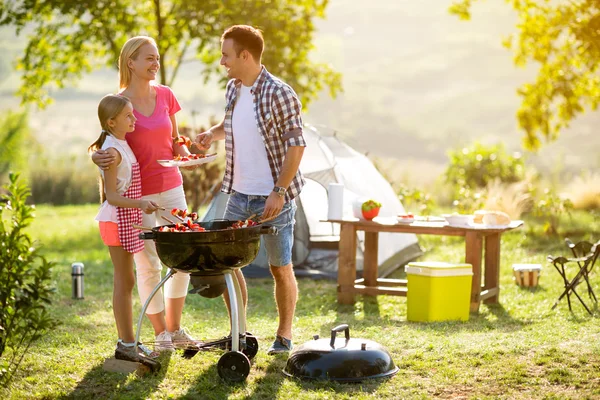 Smilende forelder grillet kjøtt med datter – stockfoto