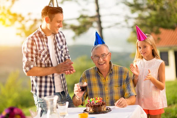 Uomo anziano che festeggia il compleanno con la famiglia — Foto Stock