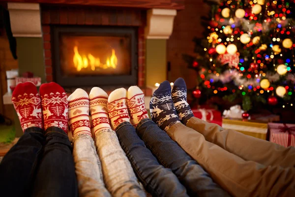 Pies en calcetines de lana cerca de la chimenea en época de Navidad —  Fotos de Stock