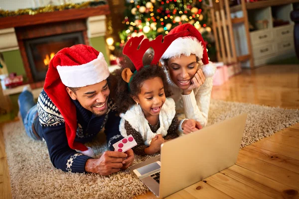 Familia sonriente tendida en el suelo frente al árbol de Navidad — Foto de Stock