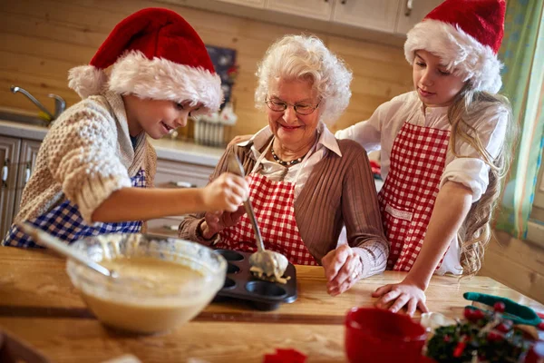 Abuela disfrutando con los niños haciendo galletas de Navidad — Foto de Stock
