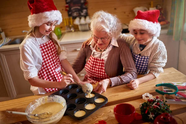 Niños disfrutando con la abuela haciendo galletas de Navidad — Foto de Stock