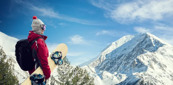 Vrouw met ski-masker holding haar snowboard — Stockfoto